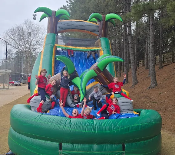Group of kids celebrating on a tropical themed inflatable water slide